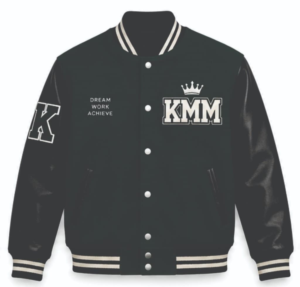 Black KMM varsity jacket with Dream Work Achieve text